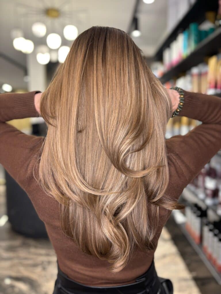 Lang karamelblond haar met laagjes en volume